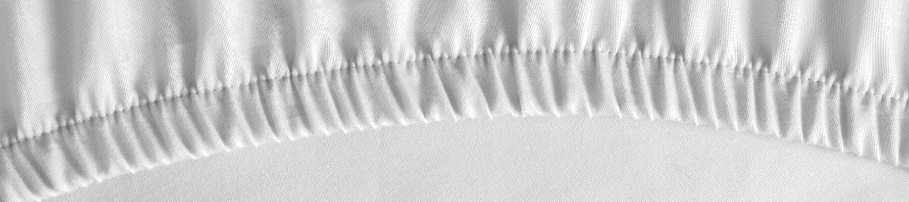 corner detail of white fitted bed sheet