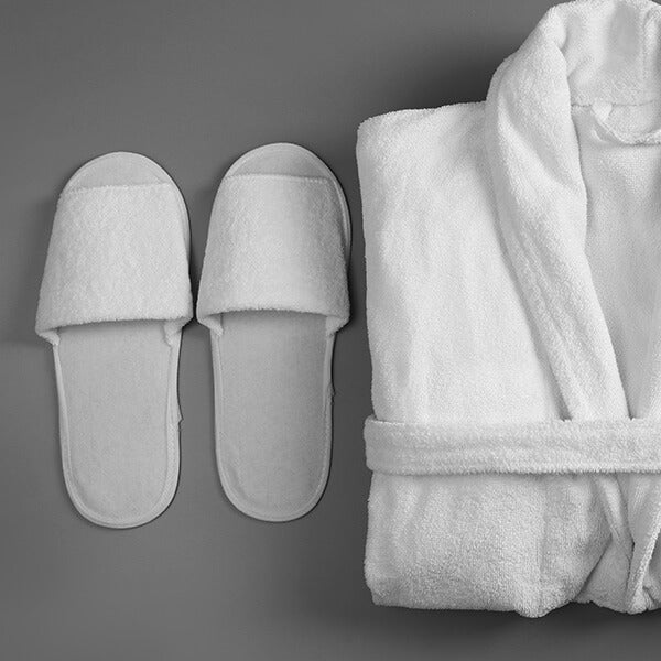 White bathrobe and slippers on a gray background
